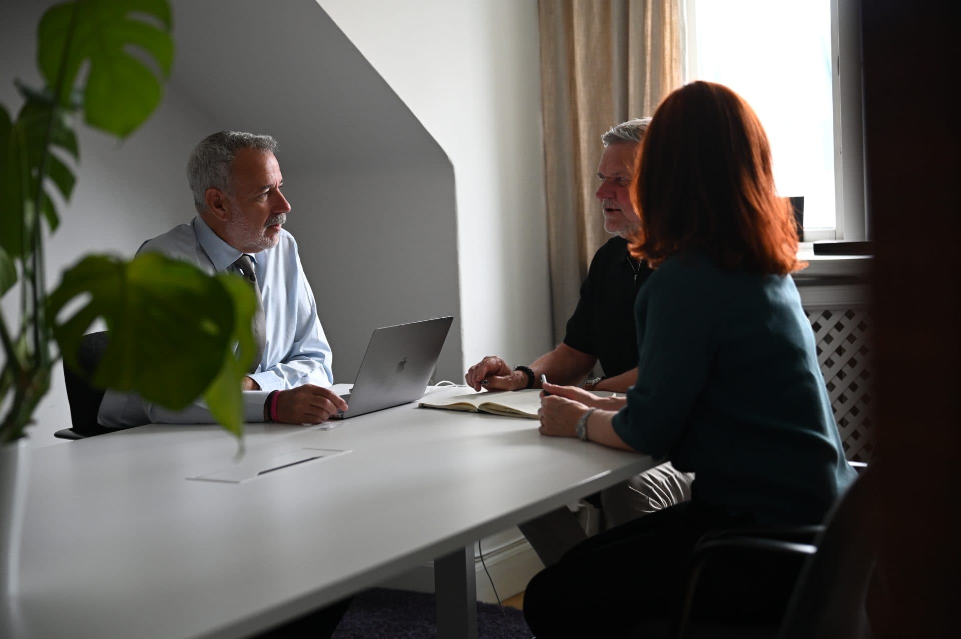 Tre rekryterare sitter runt ett bord och diskuterar.